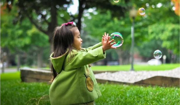 Kleines Kind spielt draußen im Garten